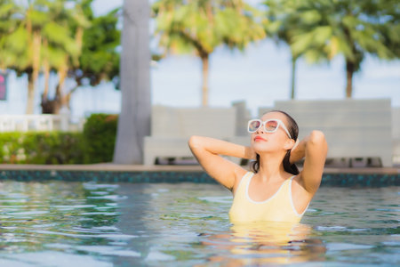 Portrait beautiful young asian woman relax smile leisure around outdoor swimming pool in holiday vacation travel tripsの写真素材