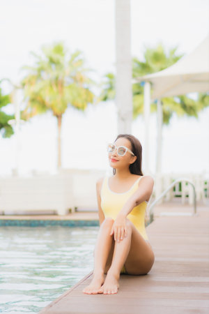 Portrait beautiful young asian woman relax smile leisure around outdoor swimming pool in holiday vacation travel tripsの写真素材