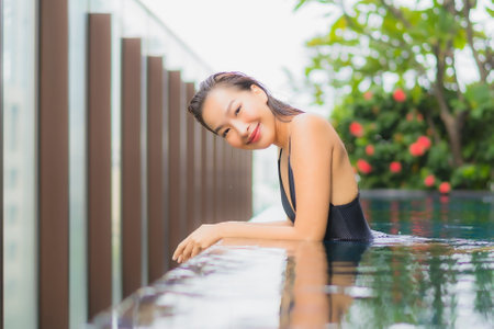 Portrait beautiful young asian woman smile relax leisure around swimming pool in hotel resort for vacationの写真素材