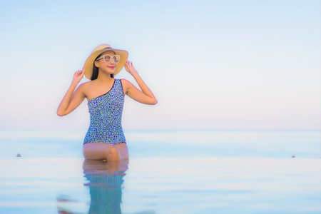 Portrait beautiful young asian woman relax smile leisure around outdoor swimming pool nearly sea beach in Travel vacationの写真素材