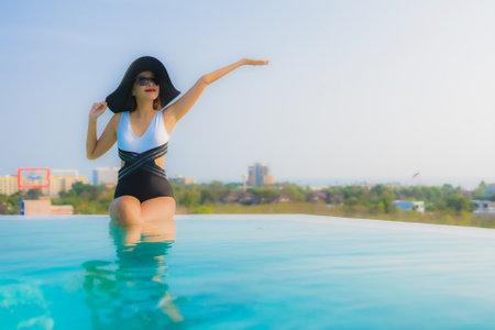 Portrait beautiful young asian woman happy smile relax around outdoor swimming pool in hotel resort for travel vacationの写真素材