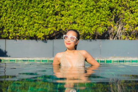 Portrait beautiful young asian woman relax smile leisure around outdoor swimming pool in hotel...