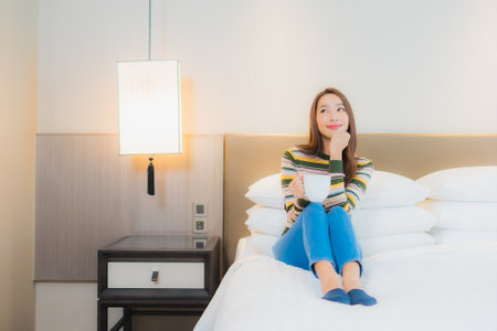 Portrait beautiful young asian woman relax smile on bed in bedroom interior