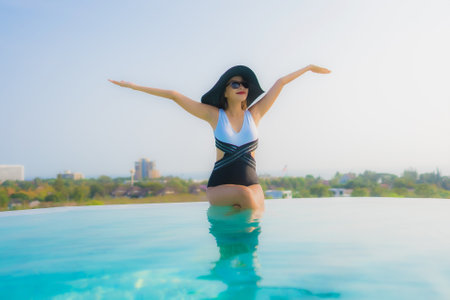Portrait beautiful young asian woman happy smile relax around outdoor swimming pool in hotel resort for travel vacationの写真素材