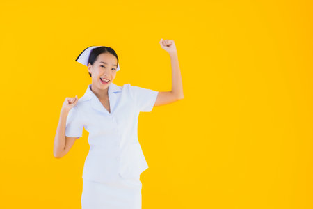 Portrait beautiful young asian thai nurse in many action work for patient in clinic and hospital on yellow isolated backgroundの写真素材