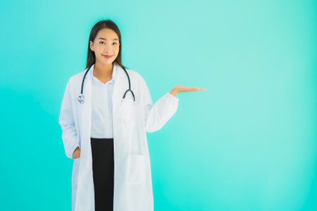 Portrait beautiful young asian doctor asian woman work at clinic or hospital on blue isolated backgroundの写真素材