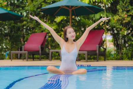 Portrait beautiful young asian woman enjoy relax smile leisure around outdoor swimming pool in hotel...