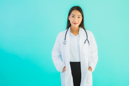 Portrait beautiful young asian doctor asian woman work at clinic or hospital on blue isolated backgroundの写真素材
