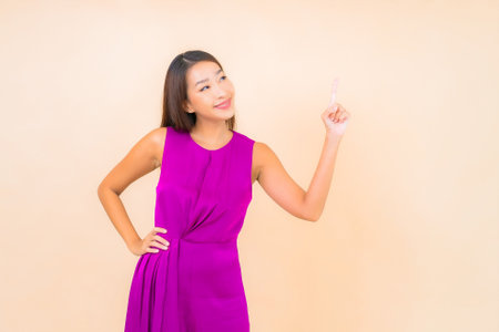 Portrait beautiful young asian woman in action on color isolated backgroundの写真素材
