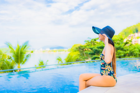 Portrait beautiful young asian woman relax smile leisure around outdoor swimming pool with sea ocean...