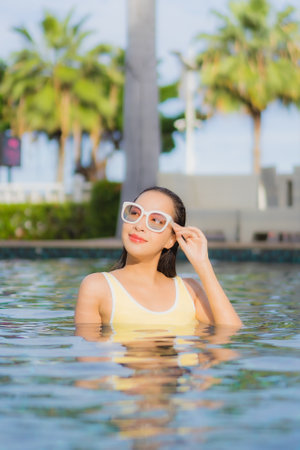 Portrait beautiful young asian woman relax smile leisure around outdoor swimming pool in holiday vacation travel tripsの写真素材