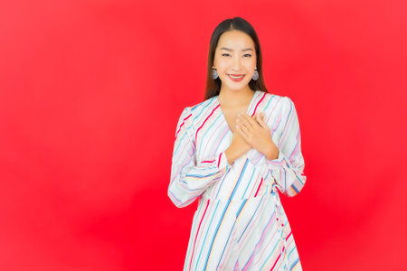 Portrait beautiful young asian woman smile with many action on red backgroundの写真素材