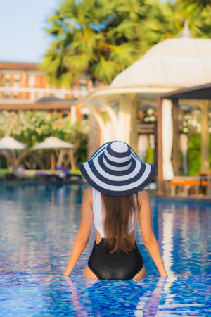 Beautiful portrait young asian woman happy smile relax around swimming pool in resort hotel for leisureの写真素材