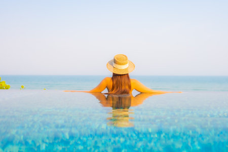 Portrait beautiful young asian woman relax smile enjoy leisure around swimming pool in resort hotel on vacationの写真素材