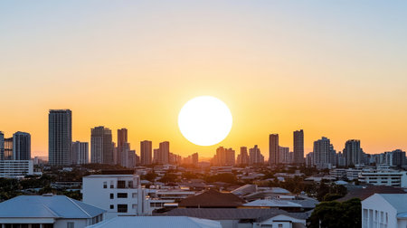 Burnt orange sunset above city skyline with tall buildings and rooftops creating sereneの素材