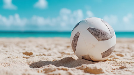 Close up of volleyball resting sandy beach with vibrant ocean backdrop, evoking sense of summerの素材