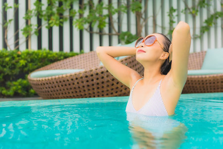 Portrait young asian woman relax leisure around outdoor swimming pool in hotel resort for travel...