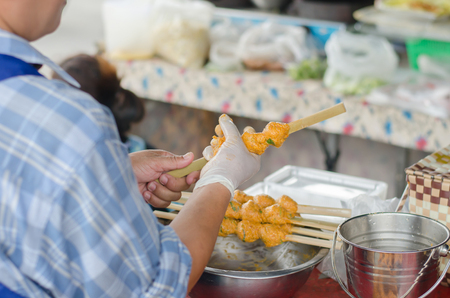 she is making curry fish cake grill on bamboo stickの写真素材