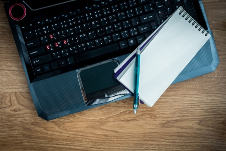 laptop and pen and blank paper on the wooden tableの写真素材