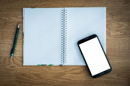 Pen and smartphone and notebook on wooden tableの写真素材