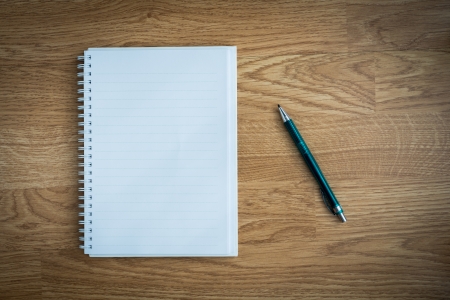Pen and notebook on wooden tableの写真素材