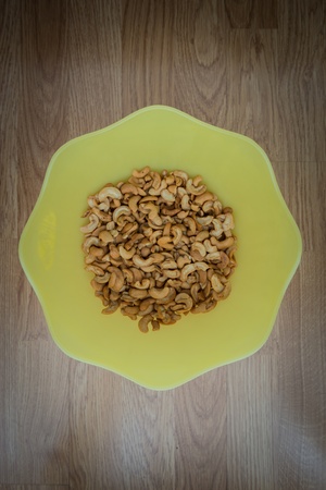 Cashew nuts in yellow bowl closeup use for backgroundの写真素材