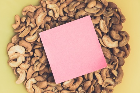 notepad on Cashew nuts in yellow bowl closeup use for backgroundの写真素材
