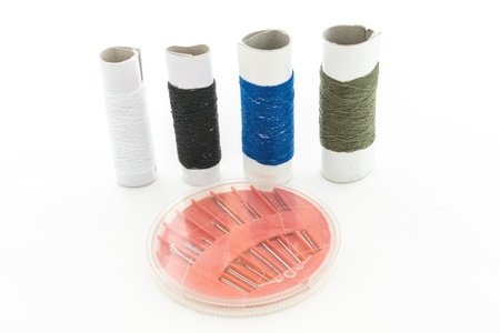Spool of thread and needle on white backgroundの写真素材