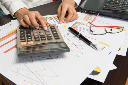 business concept - businesswoman working with calculator in officeの写真素材
