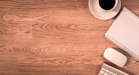 Office table with notepad, computer and coffee cup and computer mouse. View from above with copy spaceの写真素材