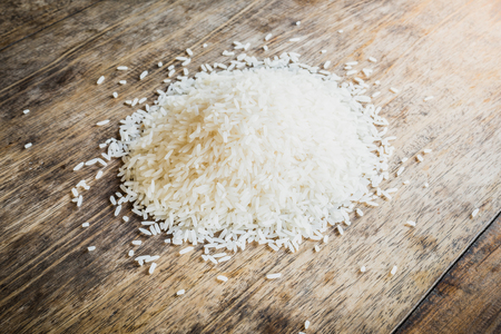 Handful of rice on a wooden table backgroundの写真素材