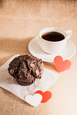 chocolate muffin and coffee and red and white hearts on sackcloth texturesの写真素材