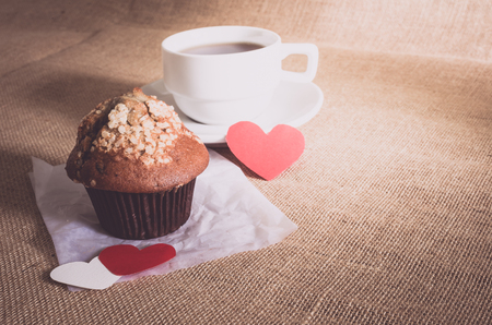 chocolate muffin and coffee and red and white hearts on sackcloth texturesの写真素材