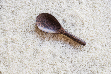 wooden spoon on rice background. view from the topの写真素材