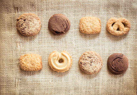Cup of coffee and biscuit on sackcloth and wooden tableの写真素材