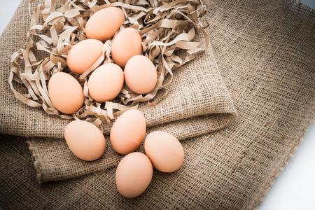 Closeup of Chicken eggs in the straw paper over sackclothの写真素材