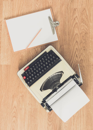 Vintage typewriter and a blank sheet of paper, retro style