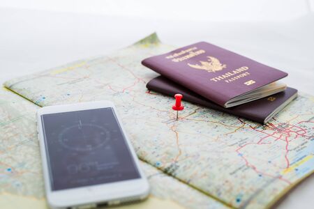 Passport on map and compasses in smartphones. red pin is mark destinations. Focus at red pin