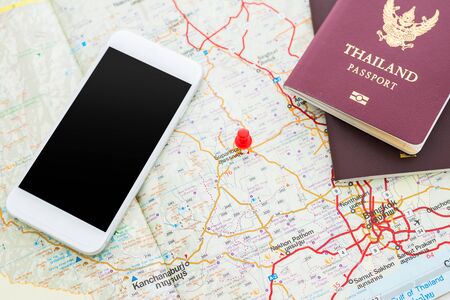 Passport on map and compasses in smartphones. red pin is mark destinations. Focus at THAILAND Passport Bookの写真素材