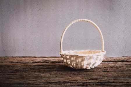 Empty wicker Basket on wooden tabletop against grunge wall. vintage toneの写真素材