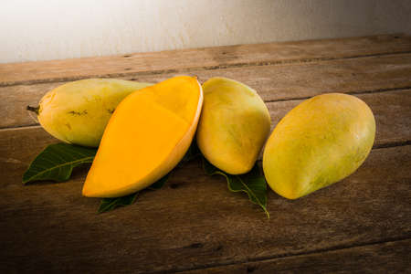 group of ripe mangoes on wooden table. vintage toneの写真素材