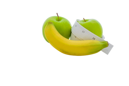 Measuring tape wrapped around a green apple and banana as a symbol of diet.