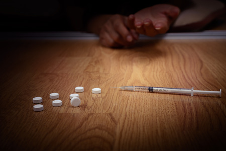 overdose male drug addict hand, drugs narcotic syringe on floorの写真素材