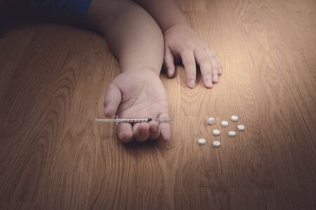 overdose male drug addict hand, drugs narcotic syringe on floor