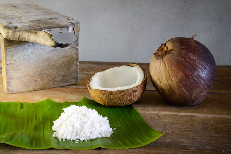 fresh coconuts and coconut flakes on banana leaf and old coconut graterの写真素材