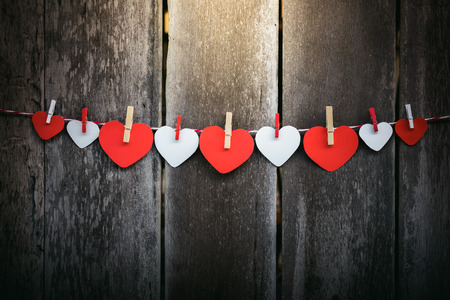 Red paper heart hanging on the clothesline. On old wood background. Valentine Conceptの写真素材