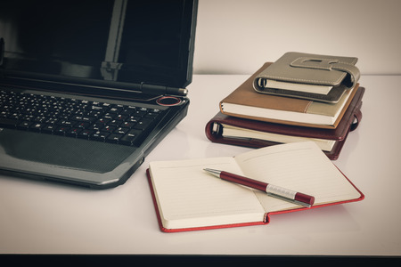 Close up Laptop Computer on Top of Office Table of a Businessman with Empty White Screen