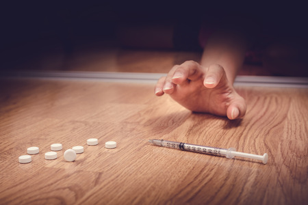 overdose female drug addict hand, drugs narcotic syringe on floorの写真素材