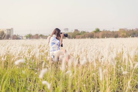 Portrait of the young Female photographer outdoors in the grass fieldの写真素材