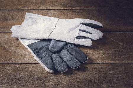 protective gloves, Standard construction safety equipment on wooden table and Light from the windowの写真素材